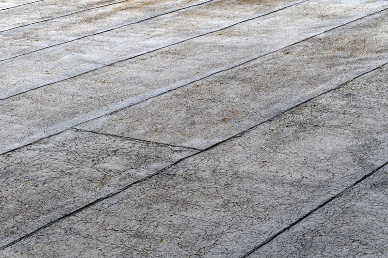 Close view of a cracked and sun-degraded flat roof membrane